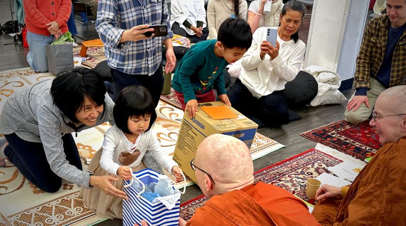 The almsgiving ceremony enabled young participants to practice the meritorious act of giving.